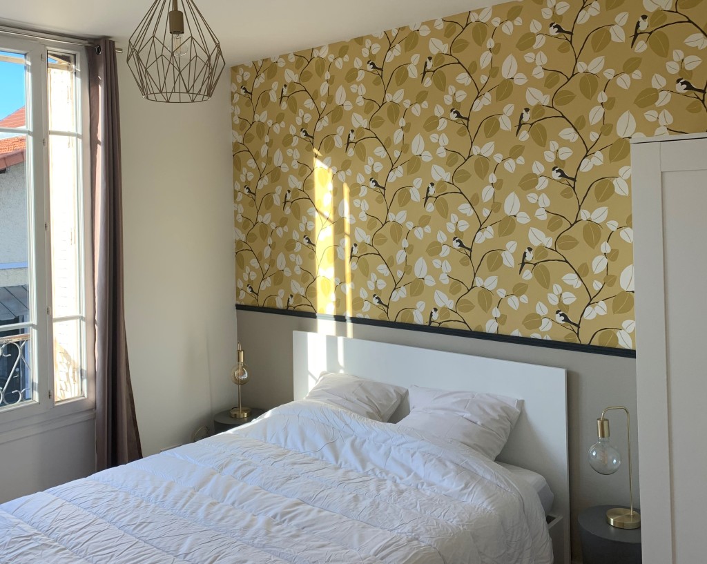 Chambre parentale avec tête de lit en papier peint jaune avec les oiseaux du projet Colombes